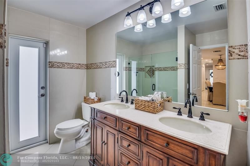 Undisclosed Address Pompano Beach, FL 33062 - Photo 41 of 63 a bathroom with a granite countertop sink a toilet and a mirror