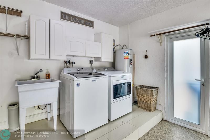 Undisclosed Address Pompano Beach, FL 33062 - Photo 46 of 63 a utility room with cabinets washer and dryer