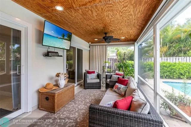 a living room with patio furniture and a potted plant