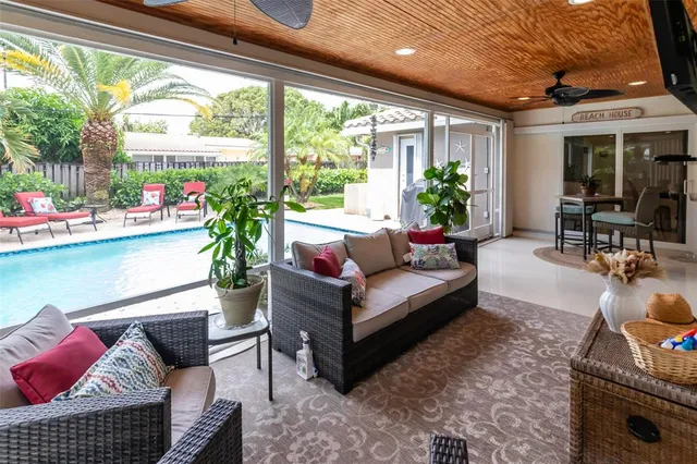 a living room with patio furniture and a potted plant