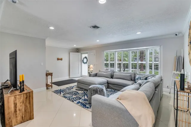 a living room with furniture a flat screen tv and kitchen view
