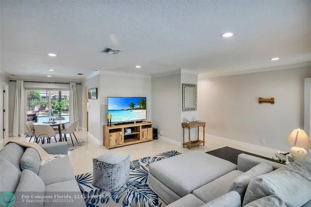 a living room with furniture a flat screen tv and kitchen view