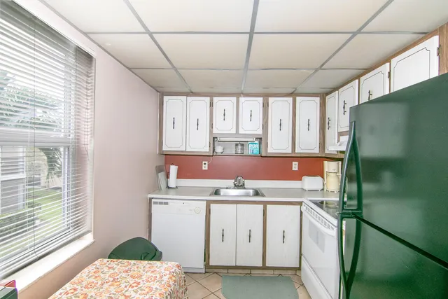 a kitchen with a sink a refrigerator and window