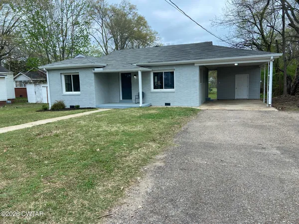 a front view of house with yard and trees