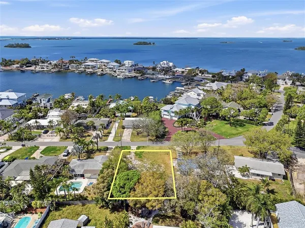 an aerial view of ocean and residential houses with outdoor space