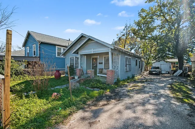 a view of a house with a yard and large tree
