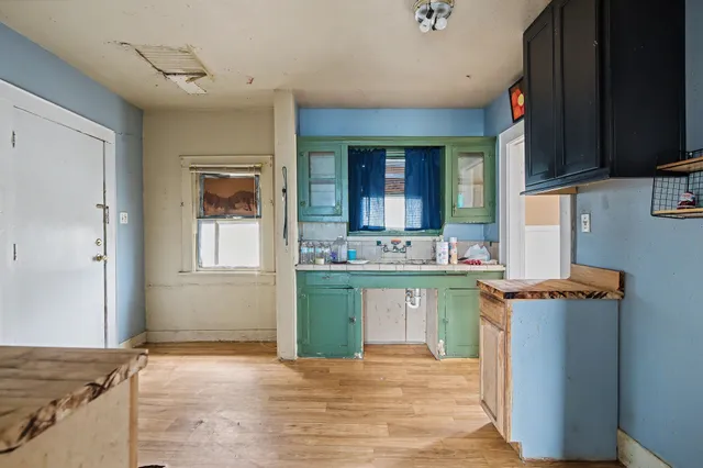 a kitchen with a sink cabinets and wooden floor