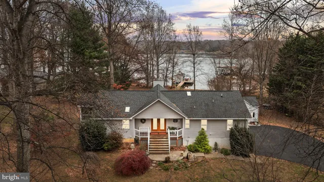 a view of house with lake and outdoor seating
