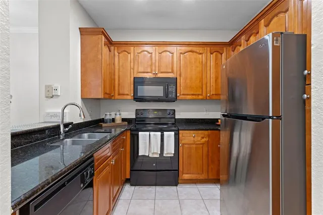 a kitchen with stainless steel appliances granite countertop a refrigerator a sink and a stove