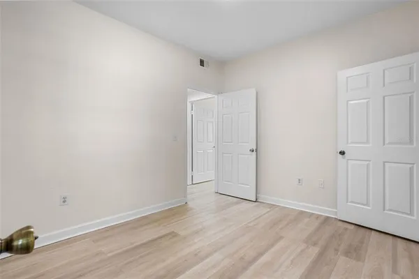 a view of a hallway with wooden floor and a door