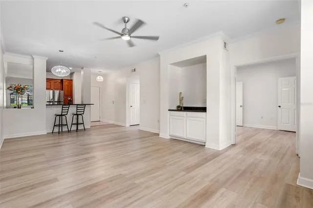 an empty room with wooden floor and a ceiling fan