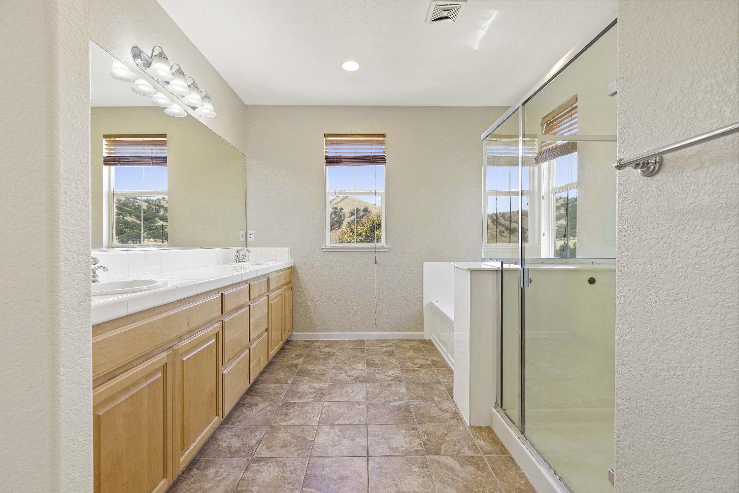 9397 Vintner Circle Patterson, CA 95363 - Photo 24 of 38 a bathroom with a sink a mirror and a bathtub