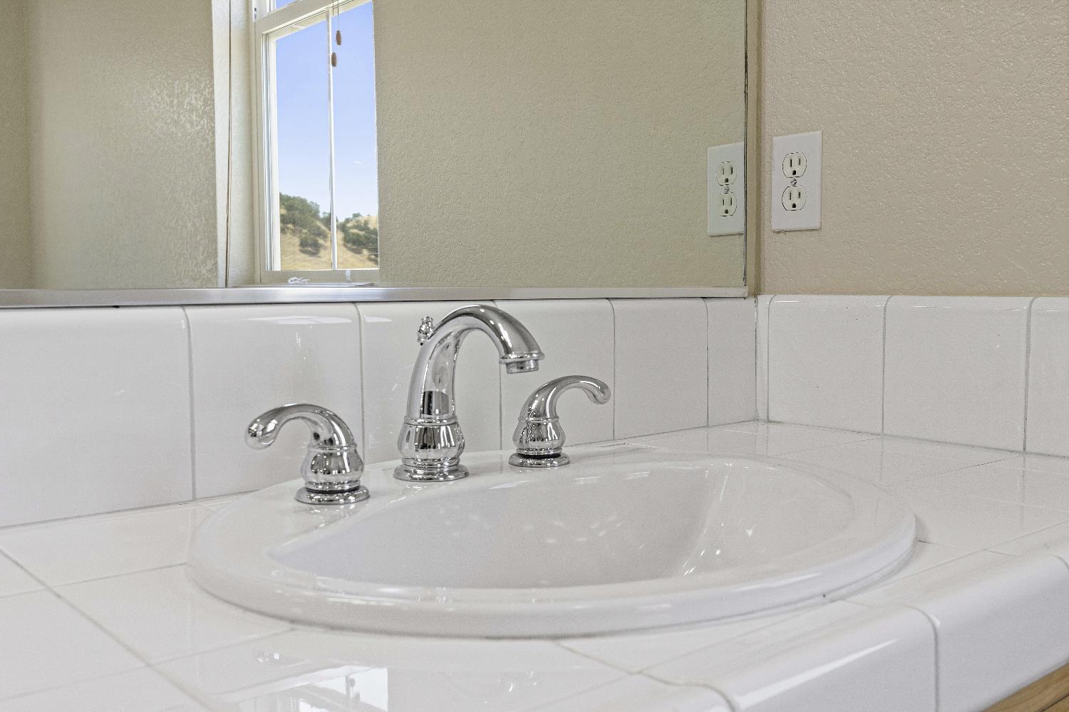 9397 Vintner Circle Patterson, CA 95363 - Photo 27 of 38 a bathroom with a sink and mirror