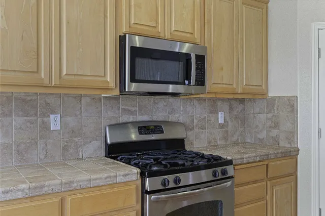 a kitchen with granite countertop a stove and a microwave