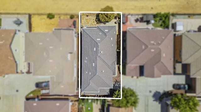 an aerial view of residential houses with outdoor space and parking