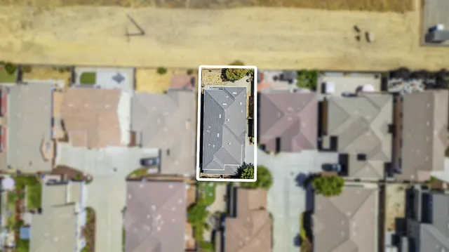 an aerial view of a house with yard and parking