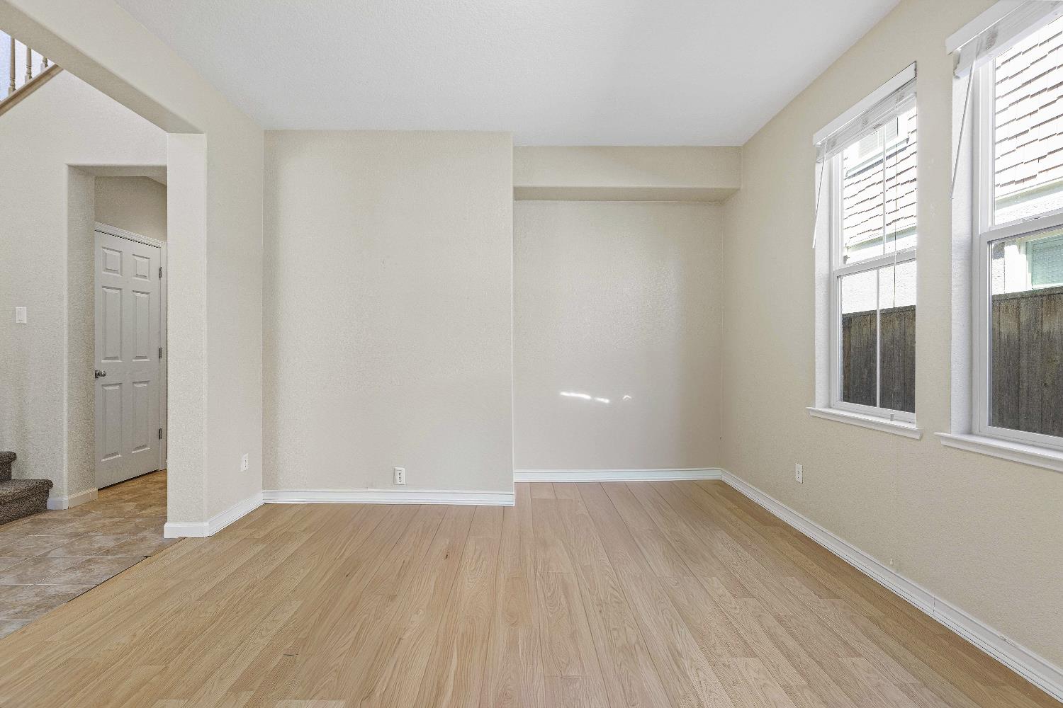 9397 Vintner Circle Patterson, CA 95363 - Photo 5 of 38 a view of an empty room with wooden floor and a window
