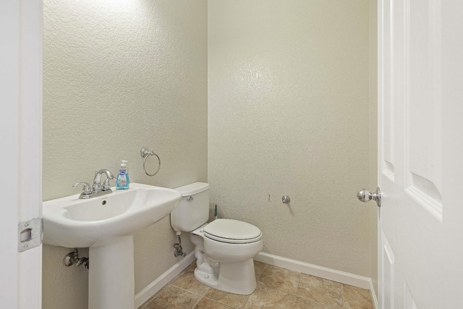 9397 Vintner Circle Patterson, CA 95363 - Photo 6 of 38 a bathroom with a sink a toilet and a mirror