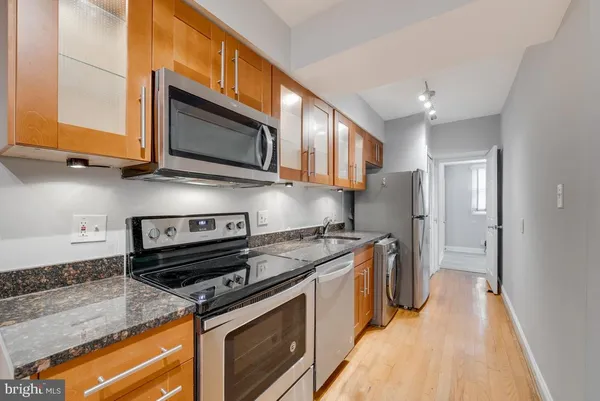 a kitchen with stainless steel appliances granite countertop a stove and a microwave