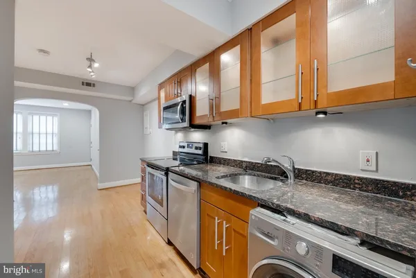 a kitchen with stainless steel appliances granite countertop a sink stove and cabinets