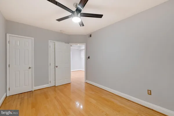an empty room with a ceiling fan and carpet