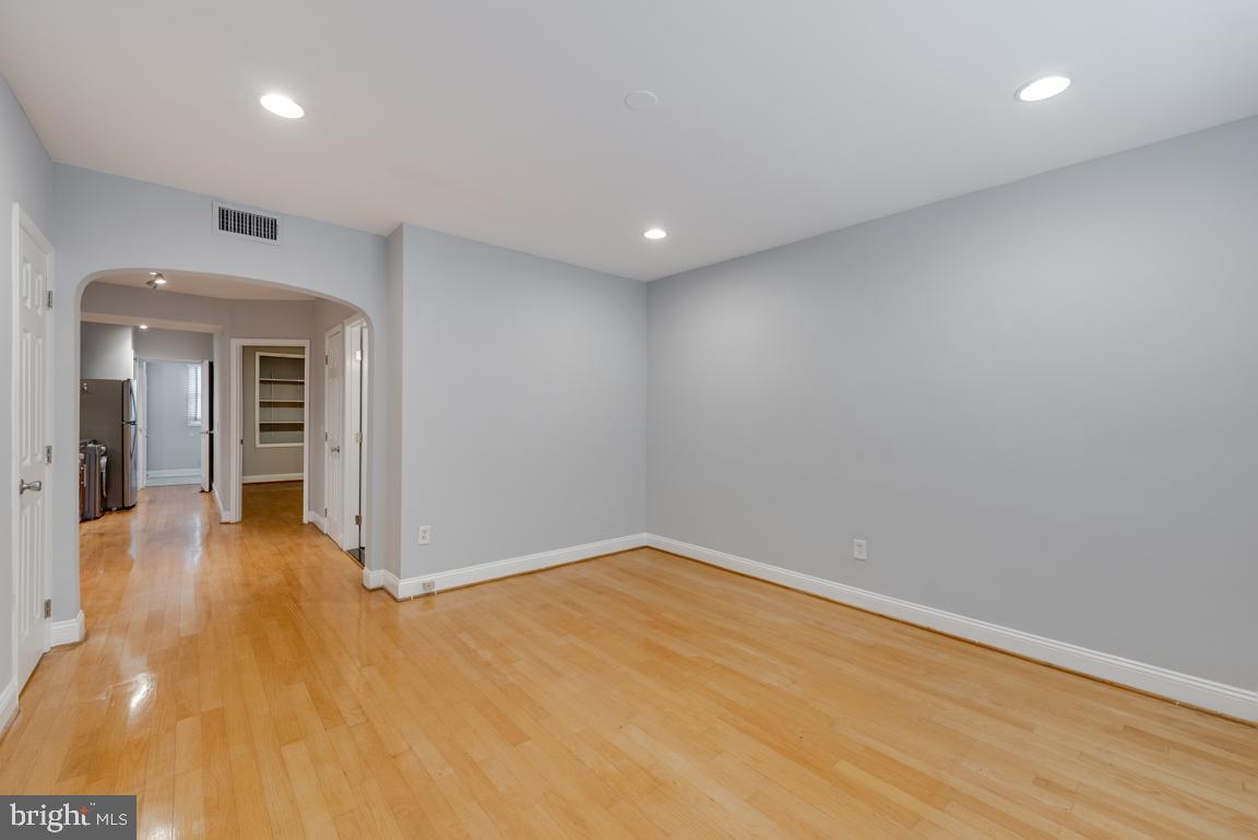 1333 Adams Street Northeast, Unit 2 Washington, DC 20018 - Photo 9 of 15 an empty room with wooden floor and natural light