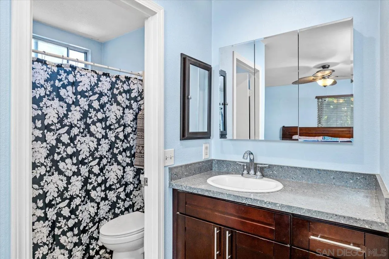 2337 Fallingleaf Road Oceanside, CA 92056 - Photo 18 of 34 a bathroom with a granite countertop sink toilet and mirror