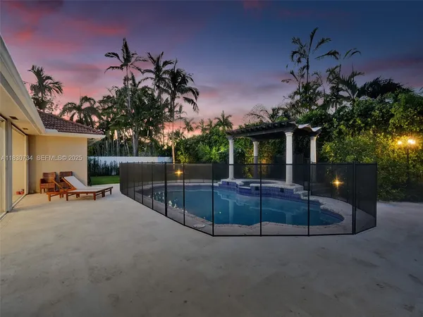 a view of swimming pool with lounge chair and dinning table under an umbrella