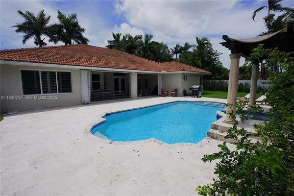 a view of a house with a swimming pool and sitting area