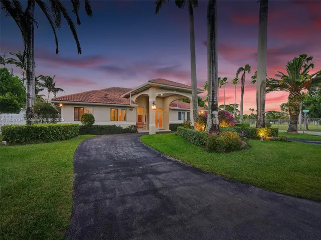 a front view of a house with a garden and plants