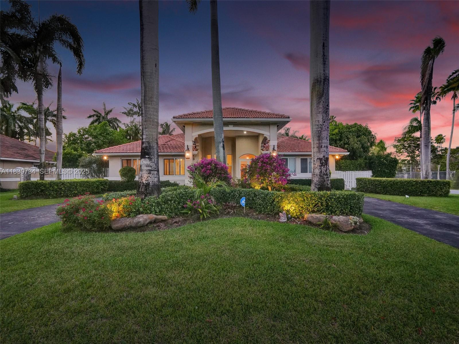 12401 Southwest 77th Street, Unit 12401 Miami, FL 33183 - Photo 3 of 95 a front view of a house with garden and a bench