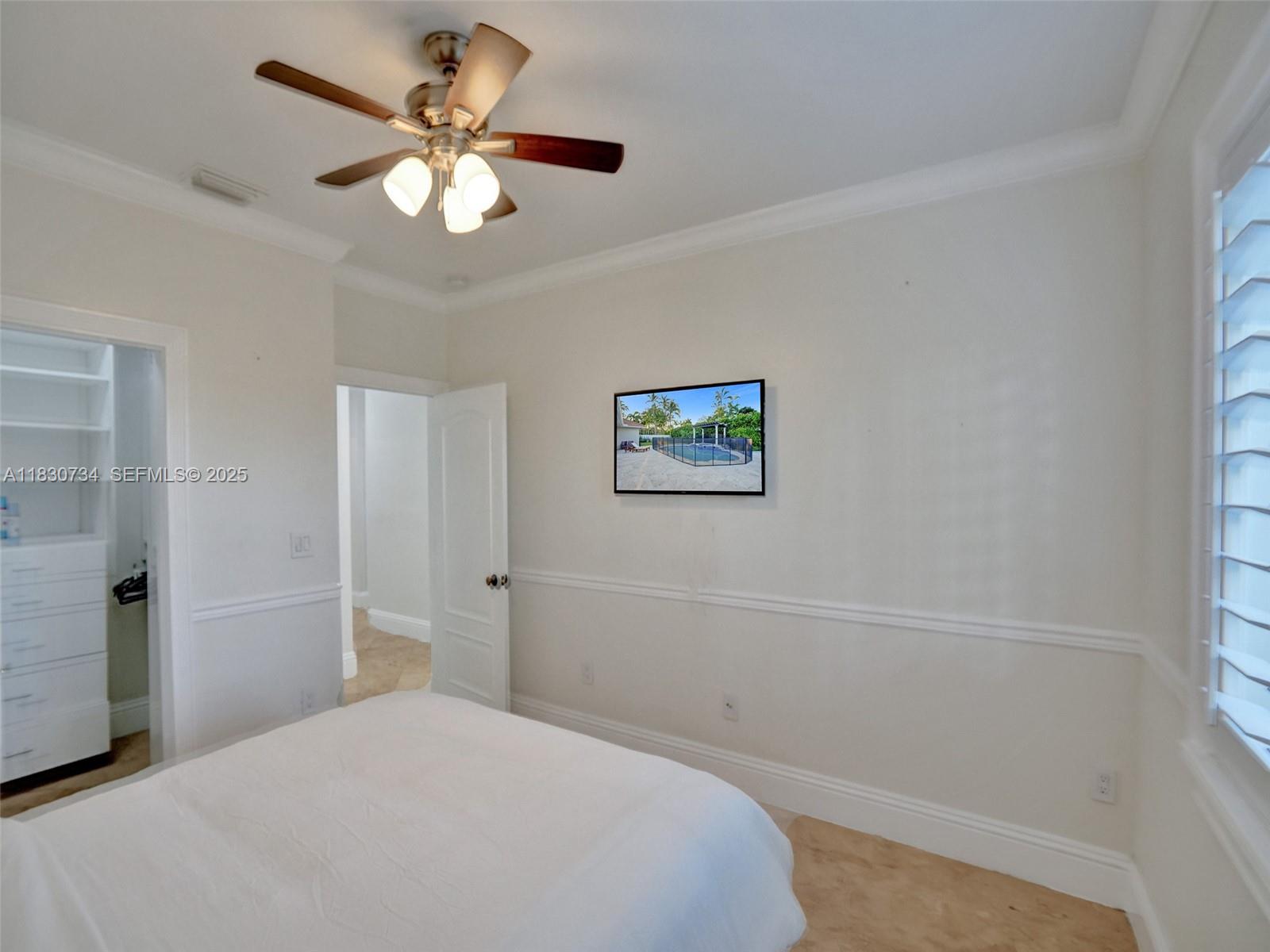 12401 Southwest 77th Street, Unit 12401 Miami, FL 33183 - Photo 90 of 95 a bedroom with a large bed and a chandelier