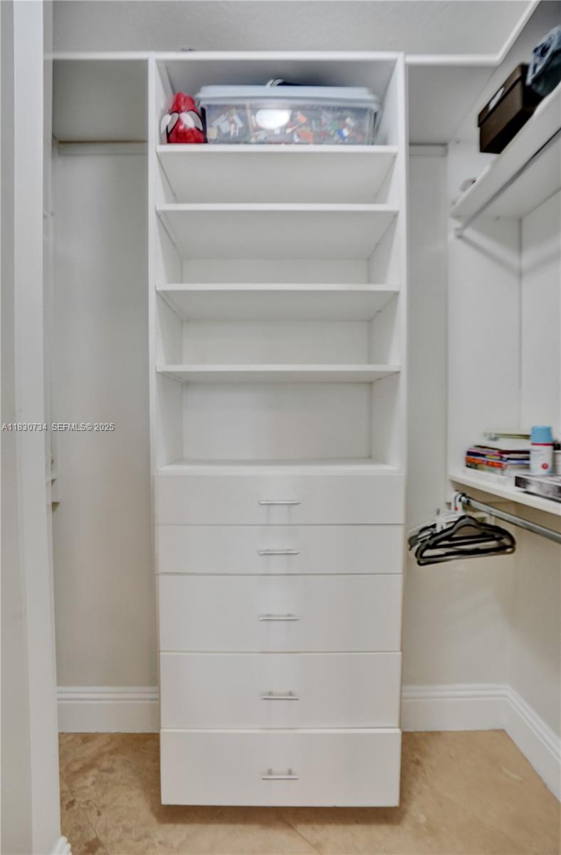 12401 Southwest 77th Street, Unit 12401 Miami, FL 33183 - Photo 94 of 95 a view of walk in closet with clothes and shoes