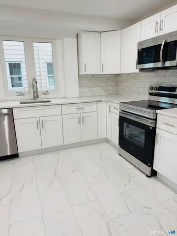 a stove top oven sitting inside of a kitchen