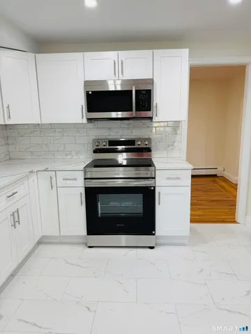 a view of a hallway with wooden floor and closet area