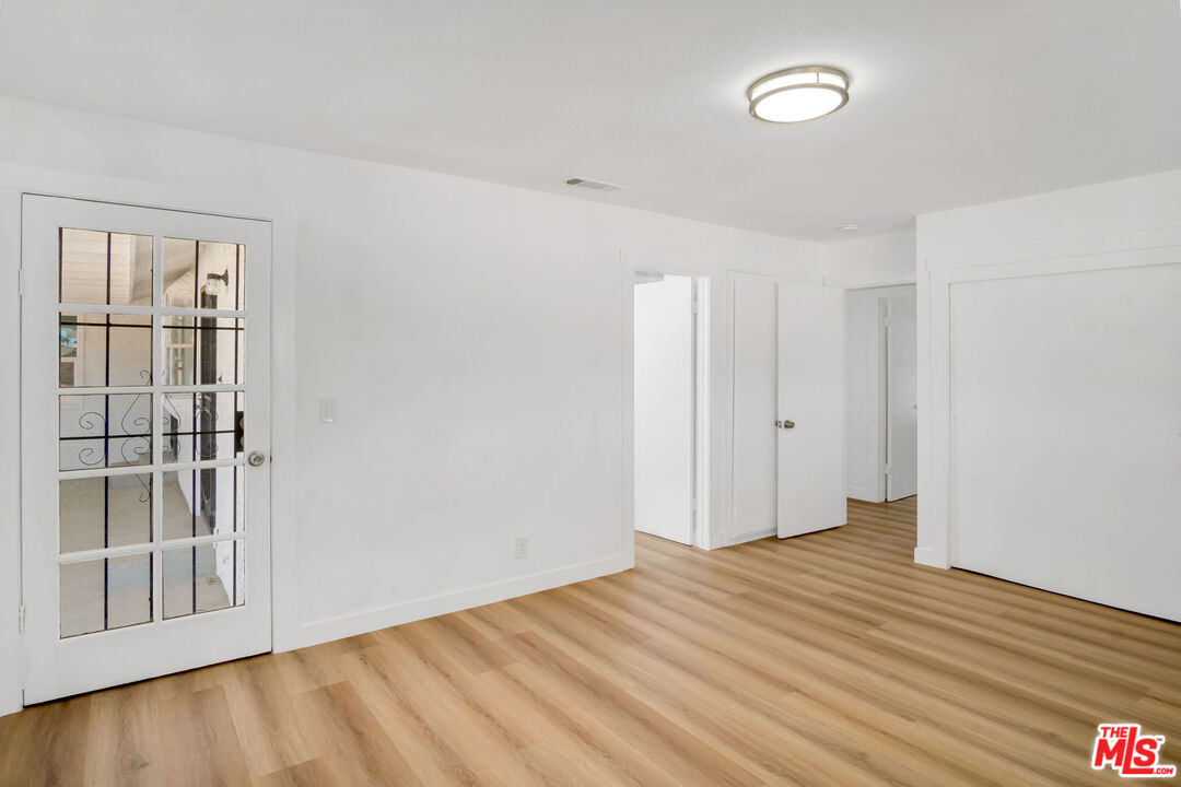 15376 Washoan Road Apple Valley, CA 92307 - Photo 19 of 40 a view of an empty room with wooden floor and a window