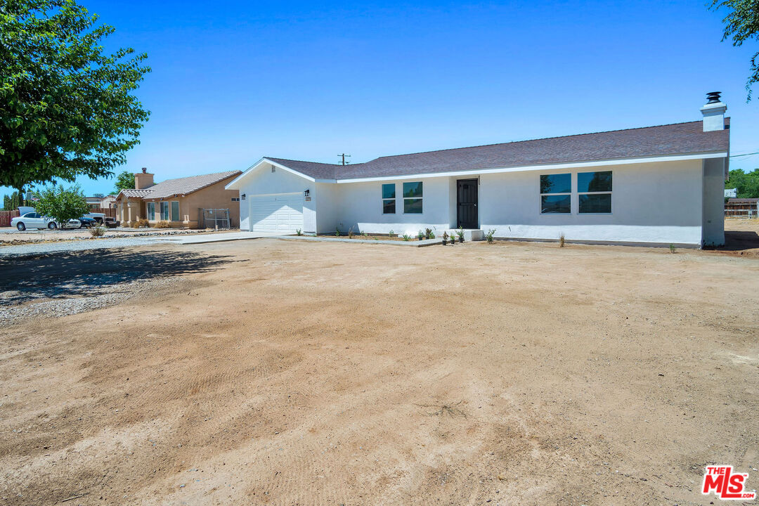 15376 Washoan Road Apple Valley, CA 92307 - Photo 2 of 40 a front view of a house with a yard and garage