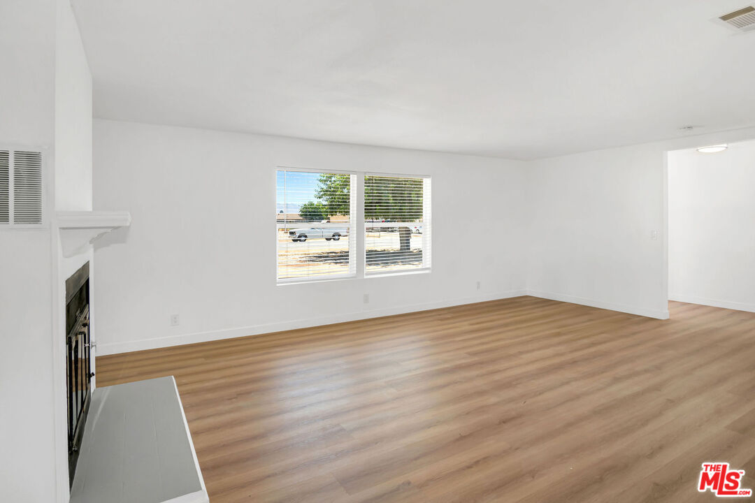 15376 Washoan Road Apple Valley, CA 92307 - Photo 30 of 40 a view of empty room with wooden floor and fan