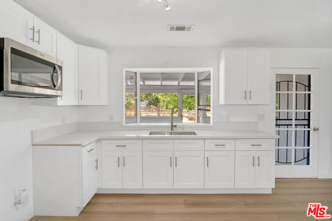 15376 Washoan Road Apple Valley, CA 92307 - Photo 7 of 40 a kitchen with stainless steel appliances granite countertop a stove a sink and a microwave