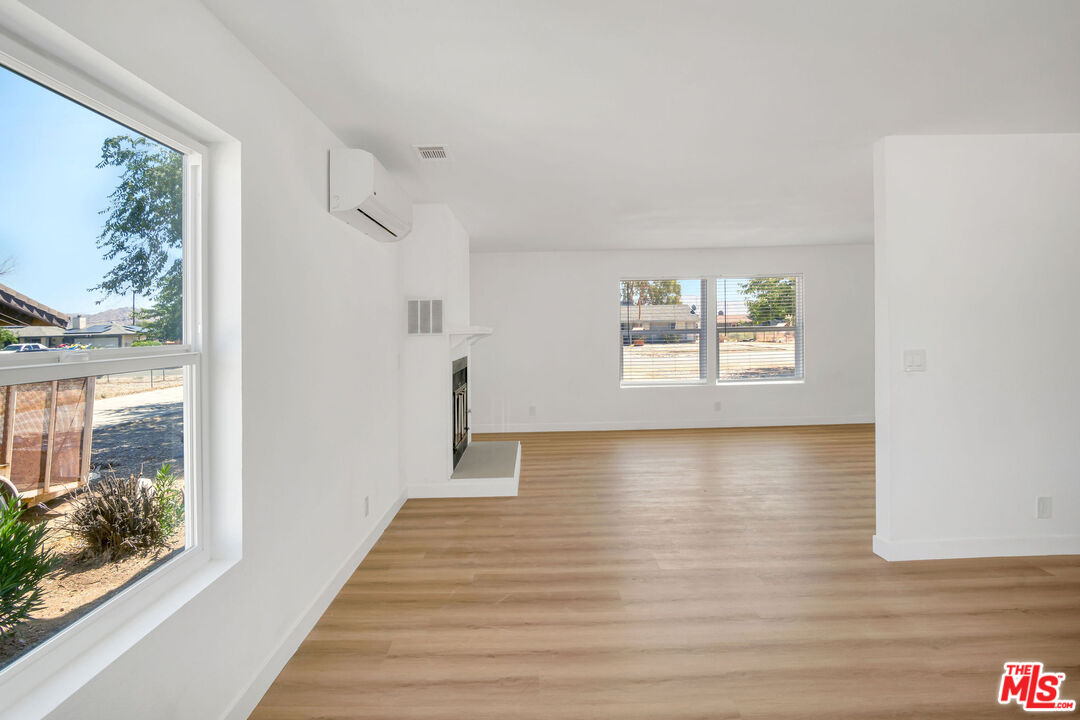 15376 Washoan Road Apple Valley, CA 92307 - Photo 10 of 40 a view of an empty room with wooden floor and a window
