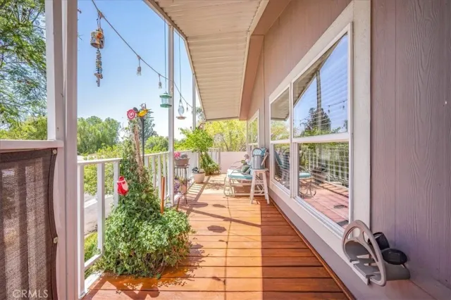 a view of a balcony with chairs and wooden floor