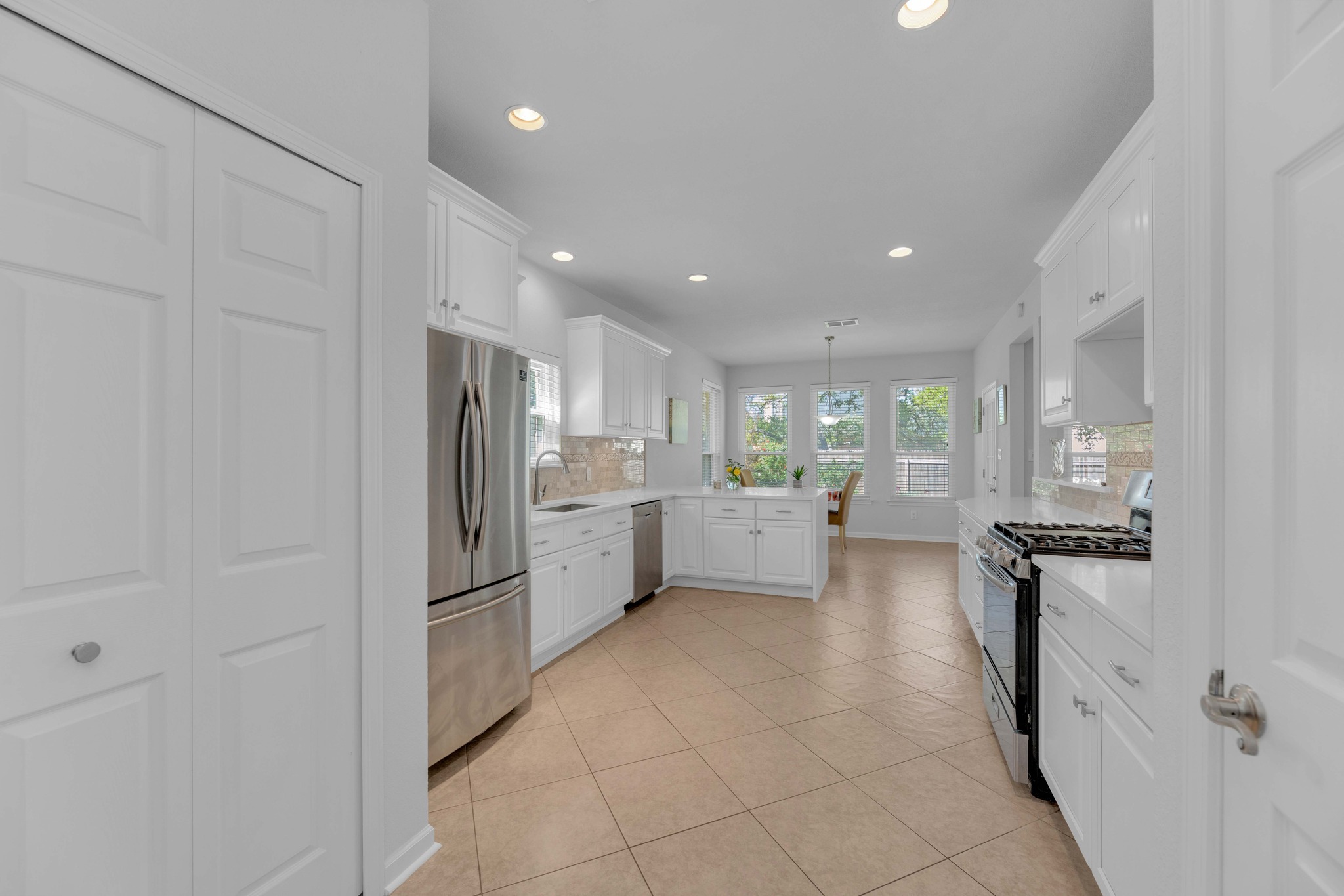 12528 Labrador Cove Austin, TX 78729 - Photo 12 of 40 Kitchen: Bright and spacious layout with quartz countertops, white cabinetry, stainless steel appliances, and abundant storage. Open design flows seamlessly to the breakfast area and living spaces, ideal for everyday living and entertaining.