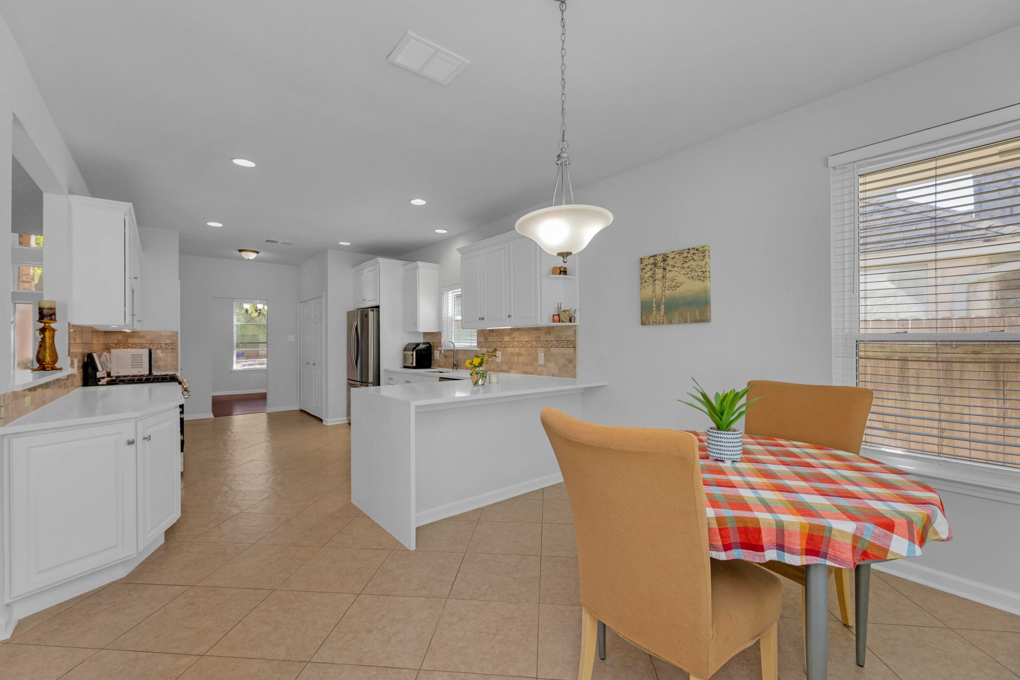 12528 Labrador Cove Austin, TX 78729 - Photo 21 of 40 Breakfast Area: Bright and inviting dining space with large windows and natural light, seamlessly connected to the kitchen. Ideal for casual meals, with an open layout that enhances everyday living and entertaining.
