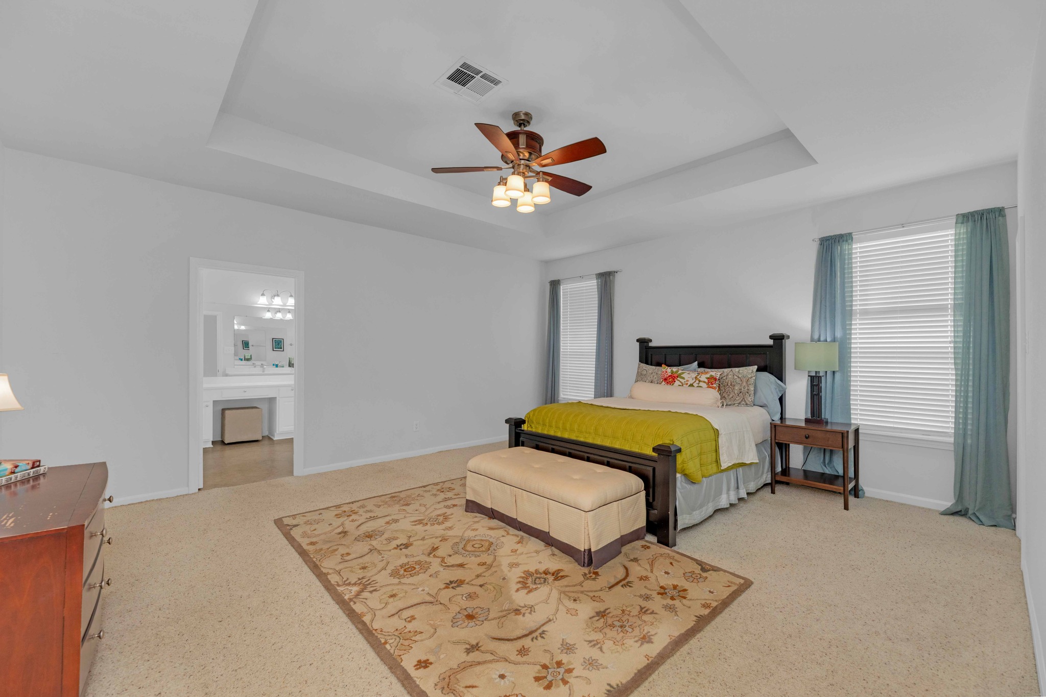 12528 Labrador Cove Austin, TX 78729 - Photo 23 of 40 Primary Suite: Spacious and private retreat featuring a tray ceiling, abundant natural light, and generous layout. Large room offers flexibility for additional seating, with direct access to the en suite bath for comfort and convenience.