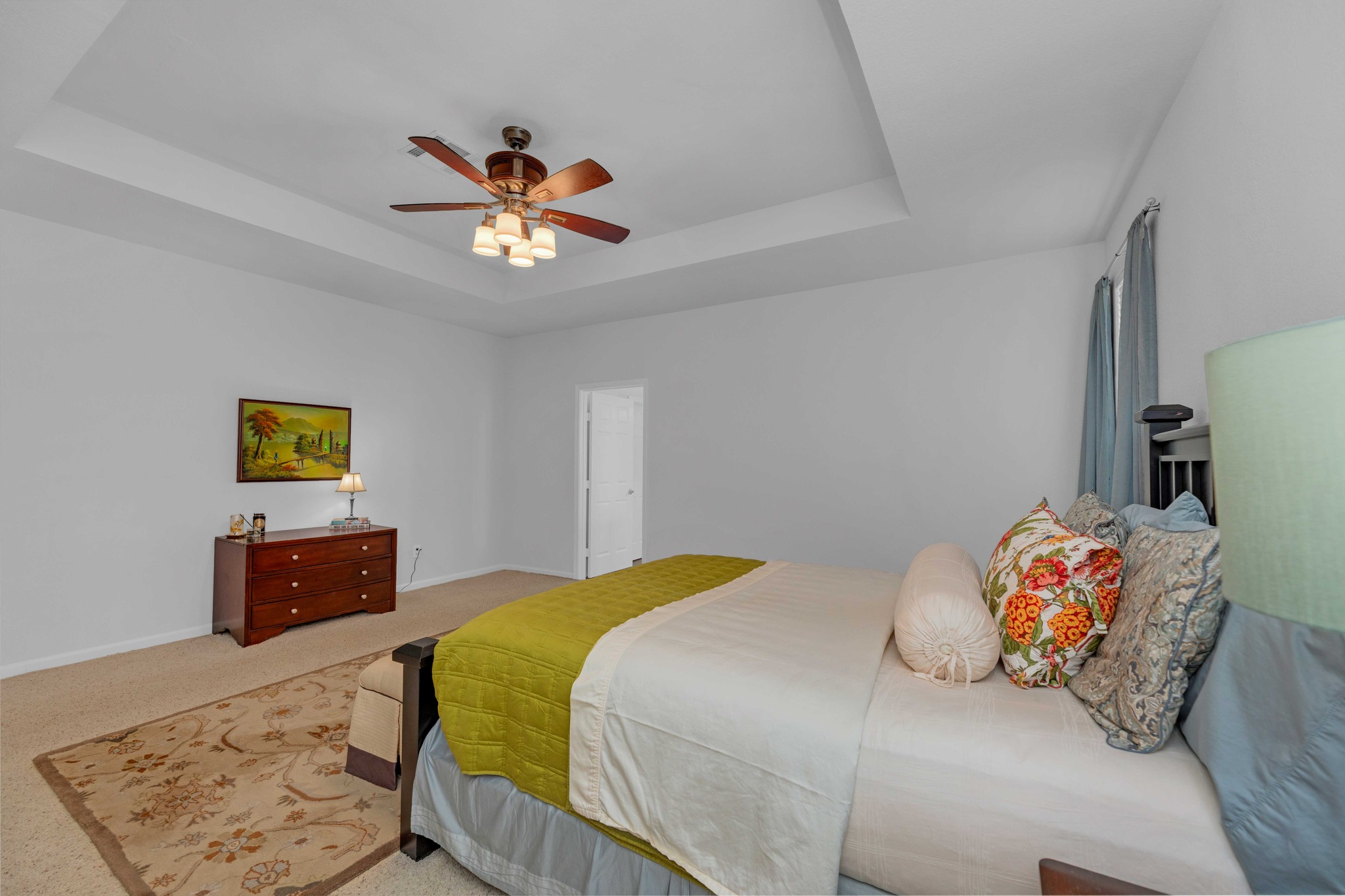 12528 Labrador Cove Austin, TX 78729 - Photo 24 of 40 Primary Suite: Generously sized retreat with tray ceiling, ceiling fan, and abundant natural light. Spacious layout offers flexibility for additional seating, creating a comfortable and private primary living space.