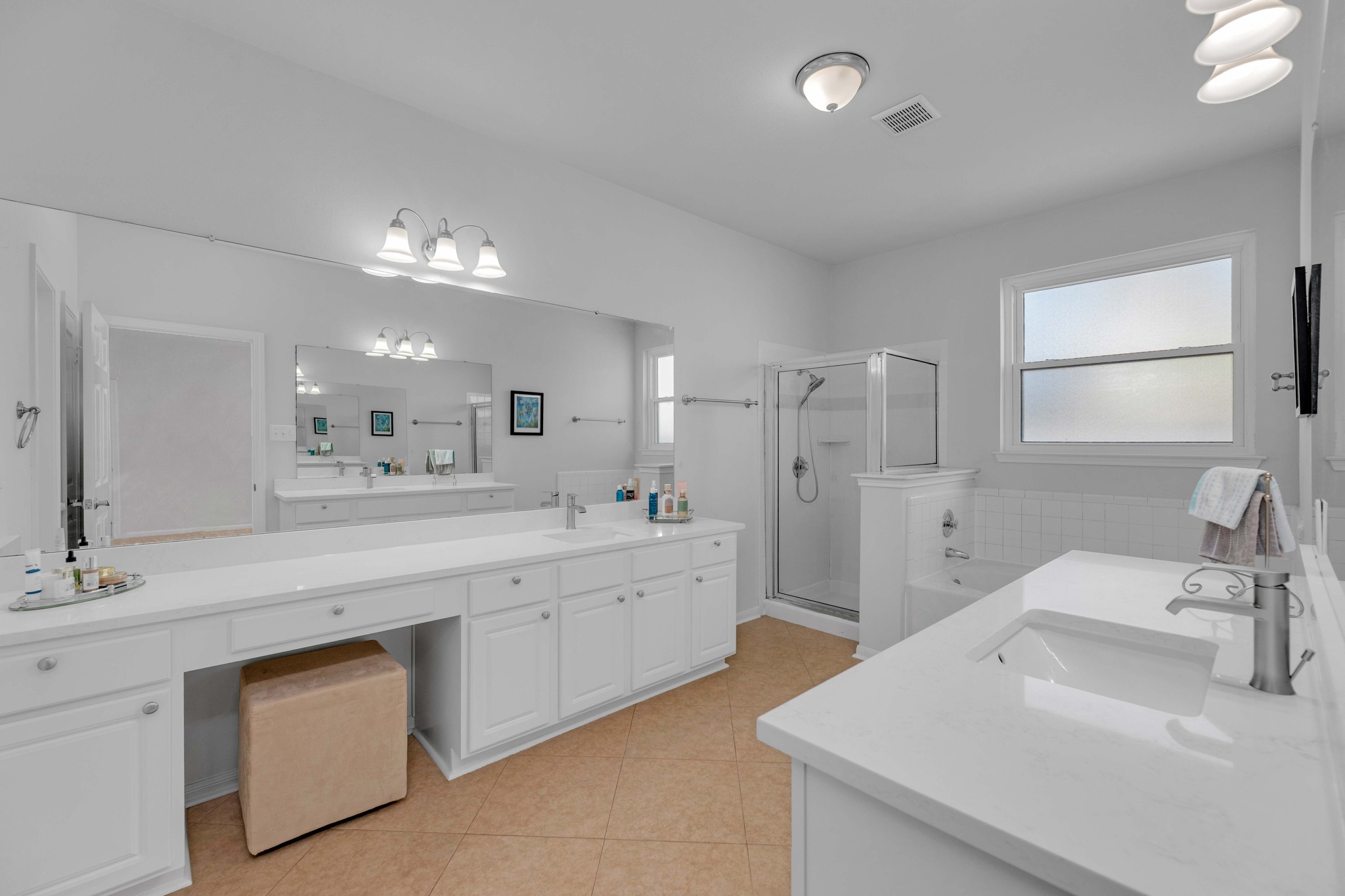12528 Labrador Cove Austin, TX 78729 - Photo 25 of 40 Primary Bath: Spacious and well appointed with dual vanities, quartz countertops, and abundant storage. Features a soaking tub, separate shower, and bright natural light, creating a comfortable and functional retreat.