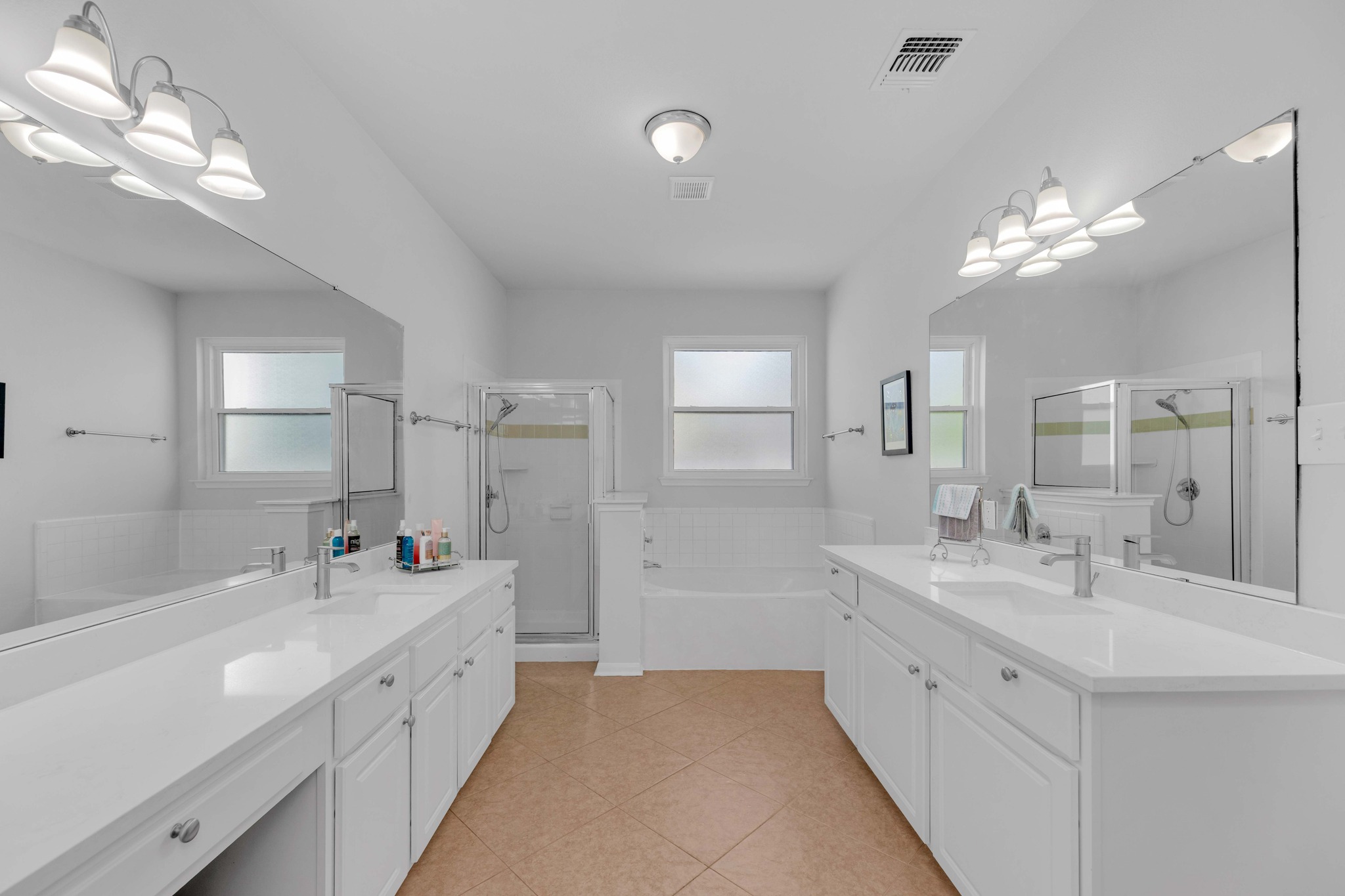 12528 Labrador Cove Austin, TX 78729 - Photo 26 of 40 Primary Bath: Spacious and well appointed with dual vanities, quartz countertops, and abundant storage. Features a soaking tub, separate shower, and bright natural light, creating a comfortable and functional retreat.