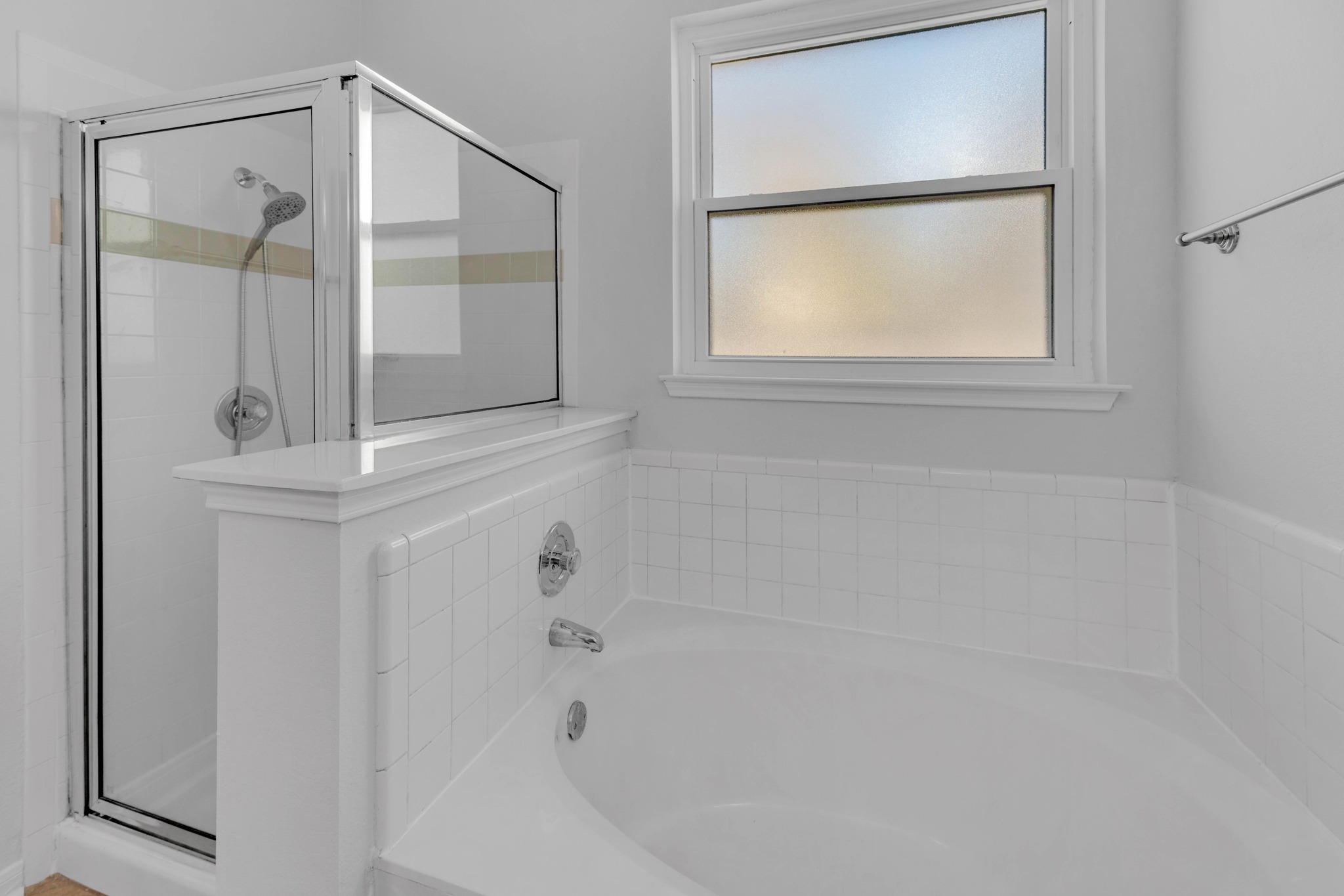 12528 Labrador Cove Austin, TX 78729 - Photo 27 of 40 Primary Bath Detail: Relaxing soaking tub with tile surround and nearby separate glass enclosed shower. Frosted window provides natural light while maintaining privacy.