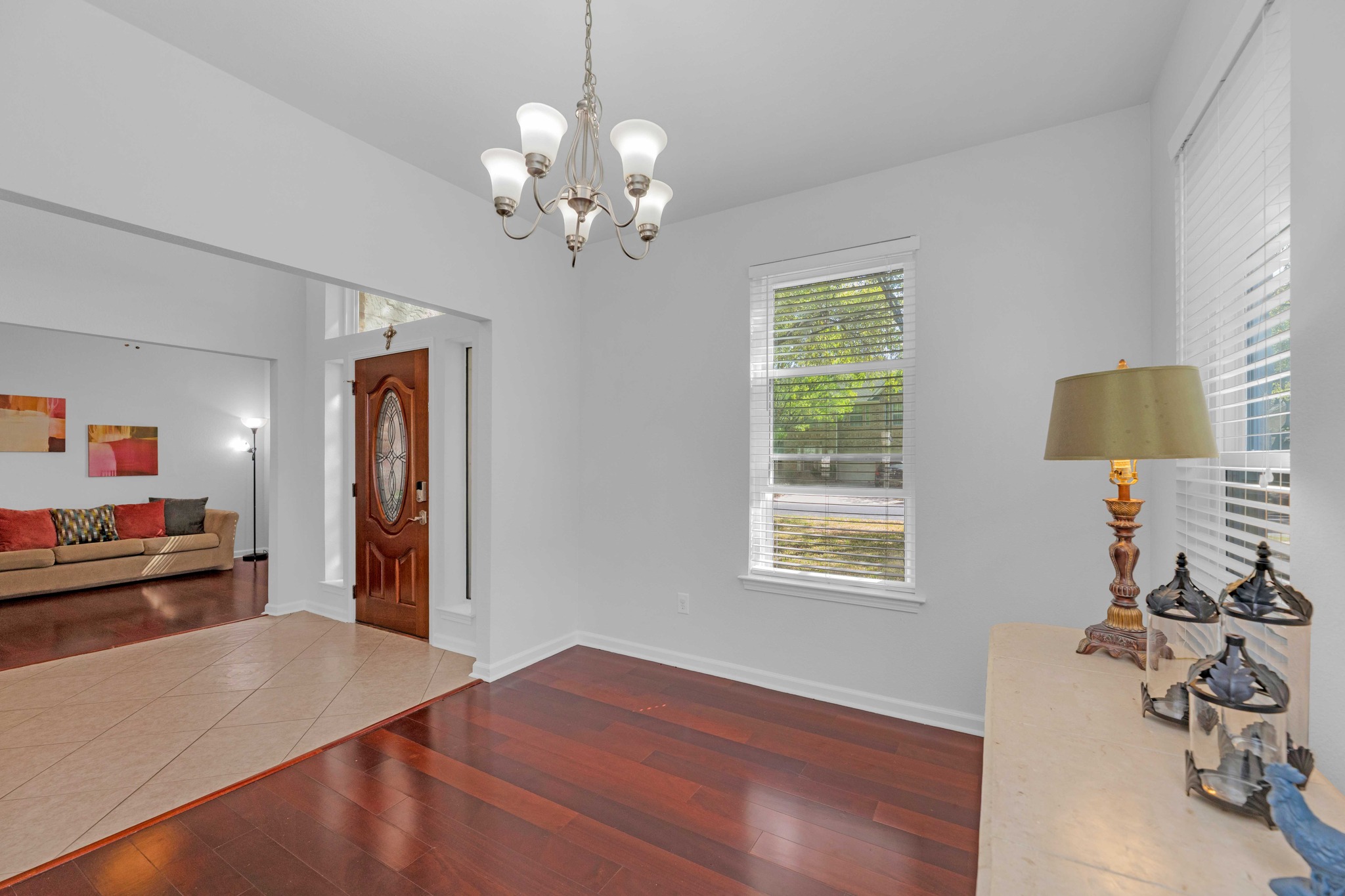 12528 Labrador Cove Austin, TX 78729 - Photo 3 of 40 Entryway featuring dark wDining Room: Bright and welcoming space with large windows, rich wood flooring, and an open connection to the entry. Ideal for everyday dining or entertaining, enhanced by natural light and clean, modern finishes.ood-style floors and suspended lighting