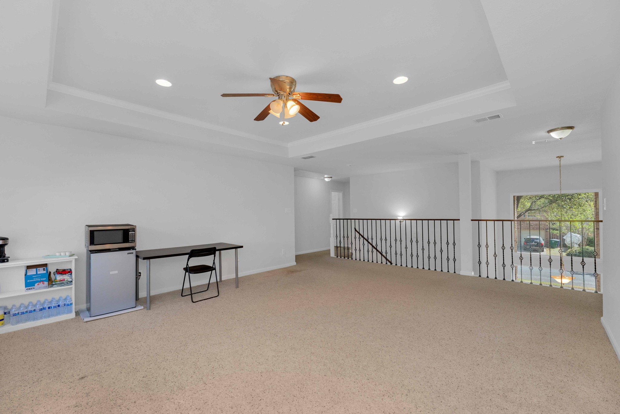 12528 Labrador Cove Austin, TX 78729 - Photo 31 of 40 Upstairs Loft / Game Room: Oversized open-concept loft with tray ceiling detail and recessed lighting, offering exceptional flexibility for a media room, game room, home office, or secondary living space. Overlooks the main level with iron railing detail and is filled with natural light from multiple windows, creating an inviting and functional extension of the home.